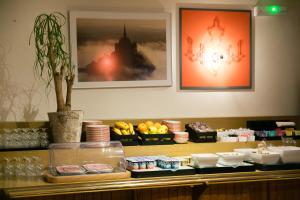 a restaurant counter with a buffet with food on it at Hôtel Vert in Le Mont Saint Michel
