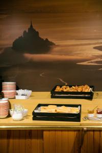 a buffet with two trays of food on a table at Hôtel Vert in Le Mont Saint Michel