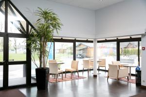 a restaurant with chairs and tables and a potted plant at Hôtel Vert in Le Mont Saint Michel