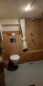 a bathroom with a toilet and a bath tub at Heranya La:Ku in Pātan