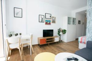 a small living room with a table and a tv at MONKÓ LOVELY, QUIET & CENTER SEA VIEWS o in Torremolinos