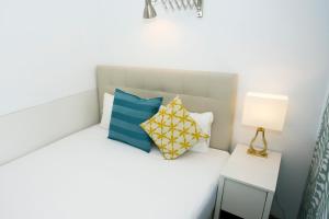 1 dormitorio con 1 cama con almohadas azules y amarillas en MONKÓ LOVELY, QUIET & CENTER SEA VIEWS o, en Torremolinos