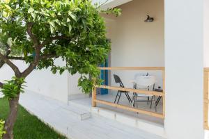a patio with a table and chairs and a tree at Scilla Marina in Mattinata