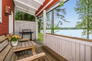 a porch with a picnic table and a grill at Hiekkarannanlomat in Kannonkoski