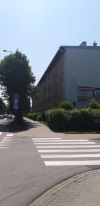 an empty street with a building and a crosswalk at Apartament w Stolicy Podhala in Nowy Targ