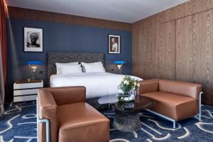 アテネにあるAthensWas Design Hotelのベッド1台と椅子2脚が備わるホテルルームです。