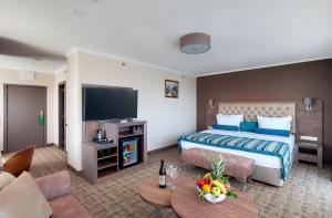a hotel room with a bed and a television at Hotel & Casino Cherno More in Varna City