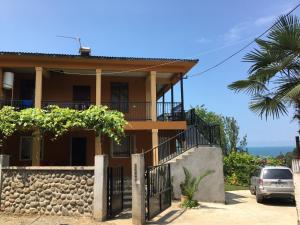 a house with a fence and a palm tree at Mahouse in Batumi
