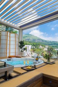 a patio with a swimming pool and a table with wine glasses at Aquaboutique Wellness&Spa in Vietri