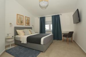 Un dormitorio con una cama y una silla y un televisor. en Apartments Bonvenon2Pula, en Pula