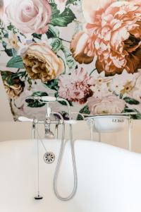 a shower in a bathroom with flowers on the wall at Gräfinhof in Nordstrand