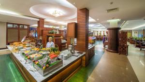 a woman standing behind a buffet in a hotel lobby at Borei Angkor Resort & Spa in Siem Reap
