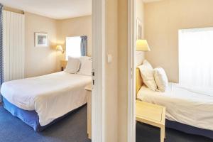 ラ・ボールにあるHôtel Vacances Bleues Villa Carolineのベッド2台と窓が備わるホテルルームです。