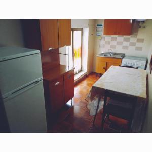a kitchen with a refrigerator and a table in it at Casa Giordano Holidays in Tramonti