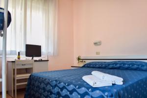 a bedroom with a blue bed with towels on it at Hotel Ville De Paris in Riccione