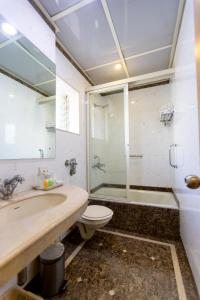 a bathroom with a sink and a toilet and a shower at Garden Hotel in Mumbai