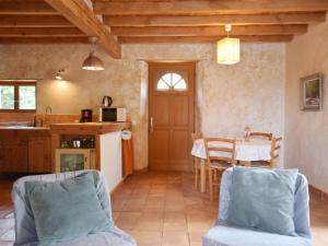 uma cozinha e sala de jantar com mesa e cadeiras em Nice holiday home with pool in Ard che em Saint Alban Auriolles