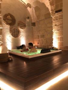 un hombre y una mujer en una bañera en Le Fornaci Imperial Lodge & Spa, en Gravina in Puglia