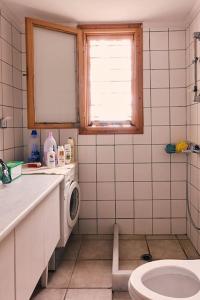 une salle de bain avec un lavabo et une machine à laver dans l'établissement Estate with amazing views of Poros, à Poros 11 autres photos