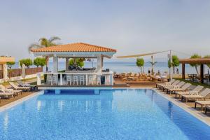 a pool at a resort with chairs and a gazebo at Villa Di Mare Seaside Suites in Ixia