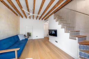 a living room with a blue couch and stairs at Loft en Santa Catalina in Palma de Mallorca