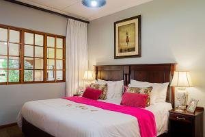 um quarto com uma cama grande e um cobertor vermelho em Glen Ormond Country House em Henburg Park