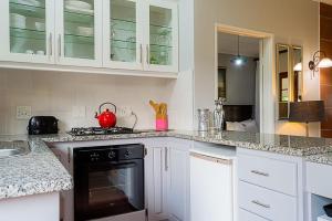 a kitchen with white cabinets and a black oven at Glen Ormond Country House in Rosetta