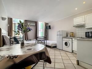 a kitchen and living room with a table and a refrigerator at Residence Chryseis in Cannes +33 photos