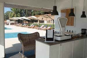 a counter with a mirror and chairs next to a pool at Casas Do Rio Sado - Sado River Country Retreat in Santa Margarida do Sado