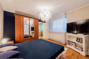 a bedroom with a large bed and a flat screen tv at Cozy beach apartment in Pärnu