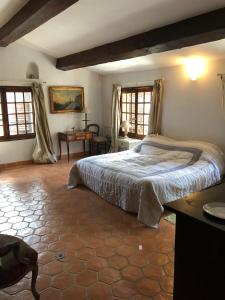 een slaapkamer met een bed en een tafel en ramen bij La Teze in Le Castellet