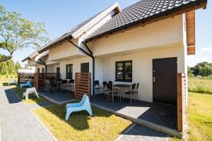Casa con patio con sillas y mesa en Baltic Holiday, en Dębki