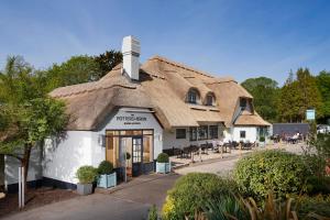 a building with a thatched roof at Potters Heron Hotel in Romsey