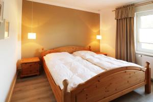 a bedroom with a wooden bed and a window at Heydens Ferienhaus_HEYD in Ostseebad Karlshagen