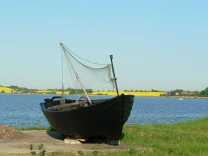 Un pequeño bote sentado al costado de un lago en Bungalow Nr_ 7 _ 8, en Binz