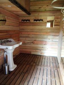 La salle de bains est pourvue d'un lavabo et de murs en bois. dans l'établissement la boutique de laurence, à Ségrie-Fontaine