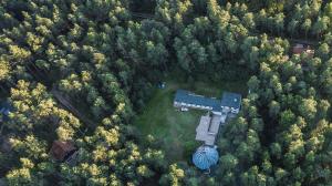 an aerial view of a house in the middle of a forest at Krokodyl in Mielno