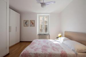 a white bedroom with a large bed and a window at "Vicolo Apartment" is a Two-story Apartment, 2BDR, additional Sofabed, 2,5 BTH, Aircondo, Pedestrian Centre, Private Parking 600mt far, easy to train and ferries, city life in La Spezia