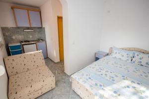 a small bedroom with a bed and a kitchen at Apartments Duskic in Utjeha