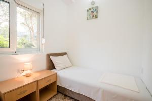 a bedroom with a bed and a desk and a window at Apartments Duskic in Utjeha