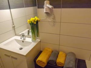 a bathroom with a sink and a mirror and yellow towels at Chalet toutou 12/14 personnes in Barèges +25 photos