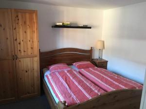 um quarto com uma cama com lençóis cor-de-rosa em Apartment Julia & Maria em Hopfgarten im Brixental