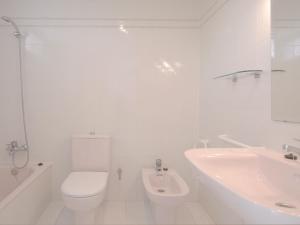 a white bathroom with a toilet and a sink at Tu&Me Resort - Adults Only in Gandía