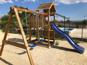um parque infantil de madeira com um escorrega e um deslizador azul em Cortijo el Ciego em Alcalá la Real