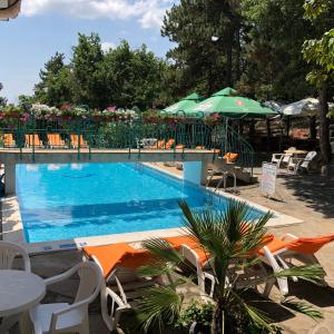 uma piscina com cadeiras, mesas e guarda-sóis em Hotel Zora em Sunny Beach