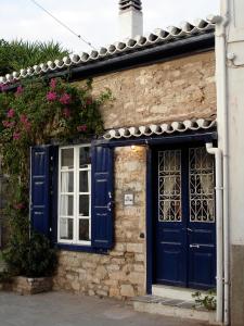 a blue door and window on a brick building at To Spitaki Apartments in Galaxidhion