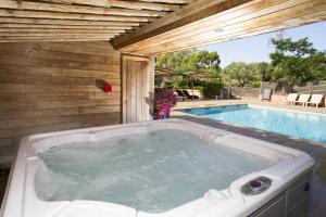 une baignoire jacuzzi installée à côté d'une piscine dans l'établissement San Giovanni, à Porto-Vecchio