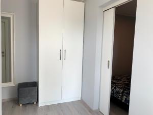um quarto com armários brancos e uma cama em Patogus Miegas IV em Anykščiai