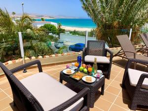 patio z krzesłami i stołem z tacą z jedzeniem w obiekcie Apartamentos Fuerteventura Sol w mieście Costa Calma