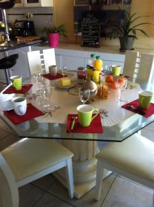 una mesa con servilletas rojas y copas de vino. en 2 chambres doubles, 1chambre 4 lits simples, Salle de bains avec balnéo thérapie en Plaine-Haute